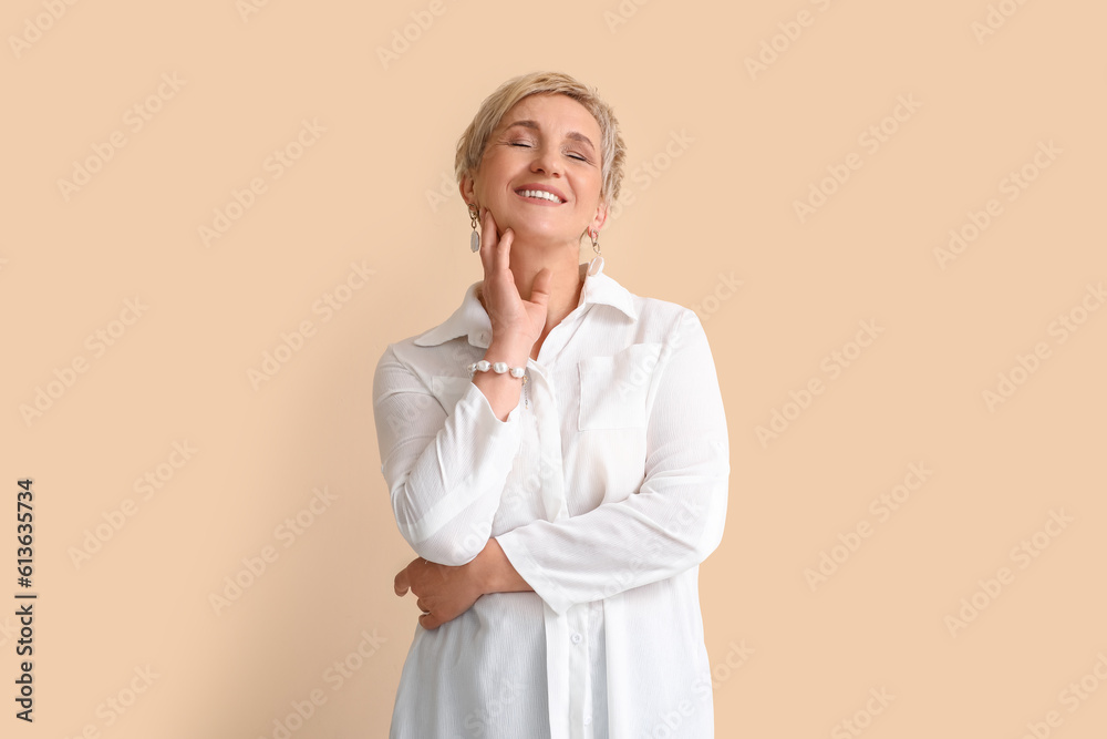 Mature blonde woman in white shirt on beige background Mature blonde woman in white shirt on beige background
