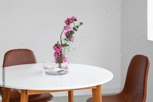 Beautiful ikebana on dining table in light room © Pixel-Shot