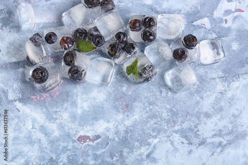 Fototapeta Naklejka Na Ścianę i Meble -  Fresh blueberry frozen in ice cubes on blue background