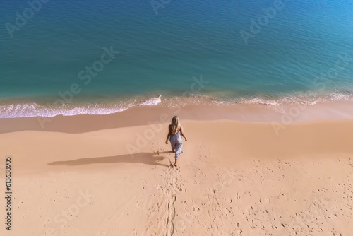Photo of a woman taking a walk by the ocean on a serene beach