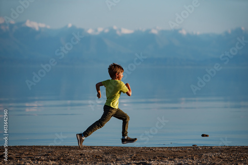 Boy running along the lake shore, Issyk-Kul lake, Kyrgyzstan