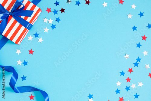 4th of July, USA Presidents Day, Independence Day. Flat lay top view of patriotic wrapping paper and gift box twinkling confetti on blue background with space, promotion or greeting message, banner