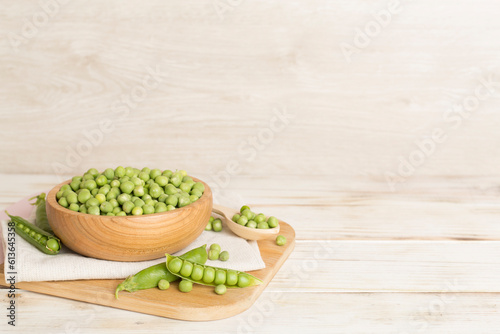 Composition with fresh green peas on wooden table
