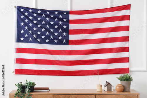 Fototapeta Naklejka Na Ścianę i Meble -  USA flag hanging on light wall in living room