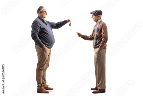 Mature man giving car keys to an elderly man