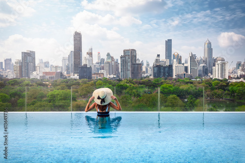 Photography A tourist woman in a swimming pool enjoys the elevated view over the Lumphini Pa