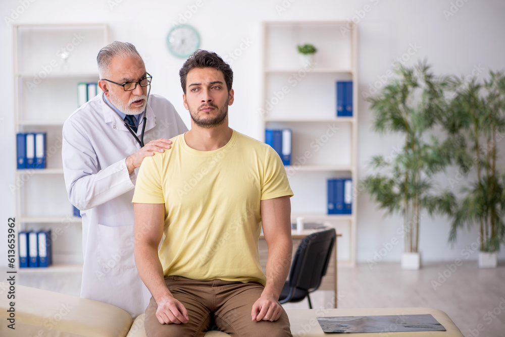 Young male patient visiting old male doctor Young male patient visiting old male doctor