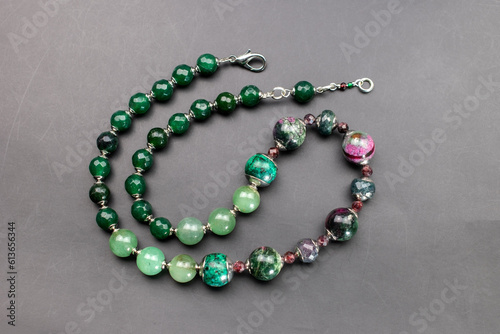 Statement green and pink stone bead necklace on black, unique handmade jewelry background, massive unusual jewelry, promotional photo for an online jewellery store