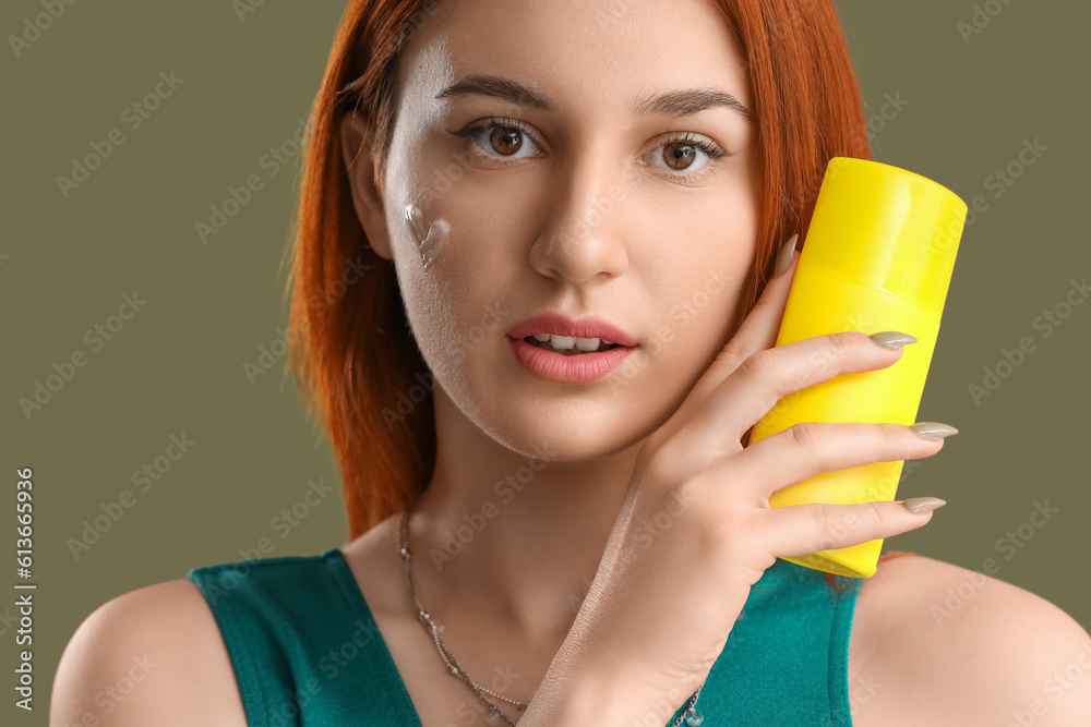 Young woman with heart made of sunscreen cream on green background Young woman with heart made of sunscreen cream on green background