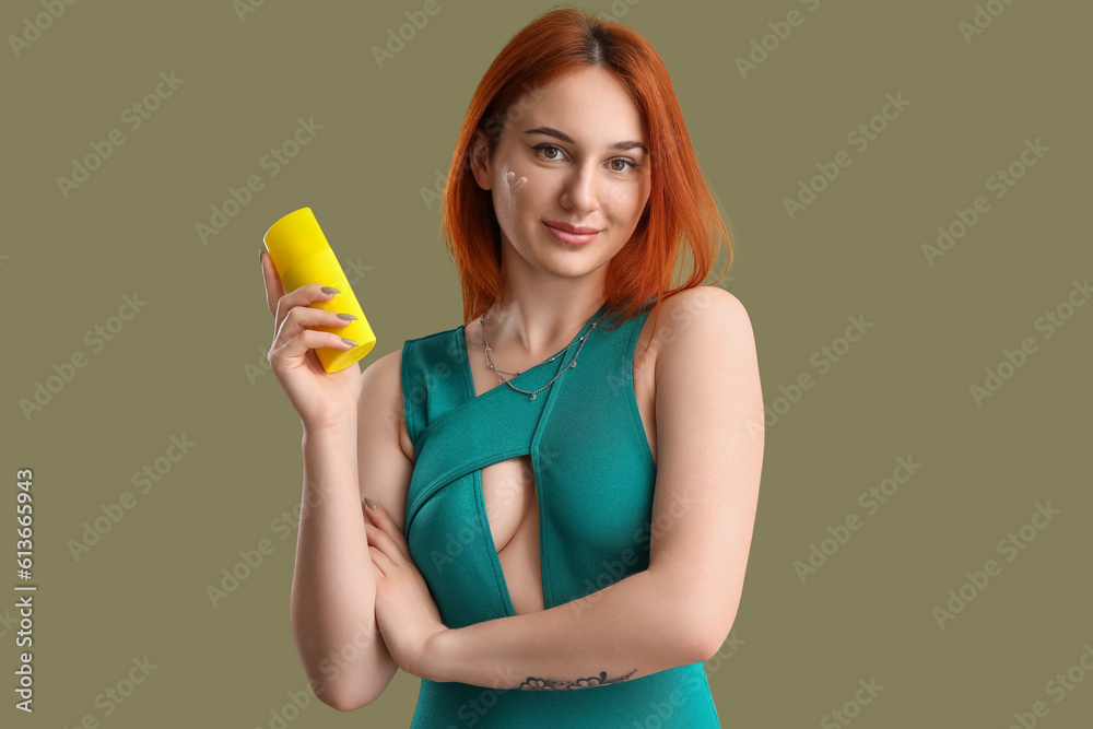 Young woman with heart made of sunscreen cream on green background Young woman with heart made of sunscreen cream on green background