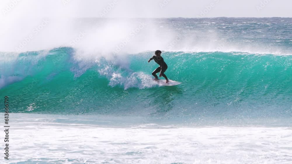 young adult surfing on a big wave in the ocean