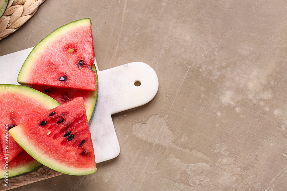Board with pieces of fresh watermelon on brown background Stock Photo