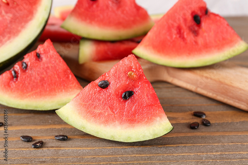 Board with pieces of fresh watermelon and seeds on wooden table