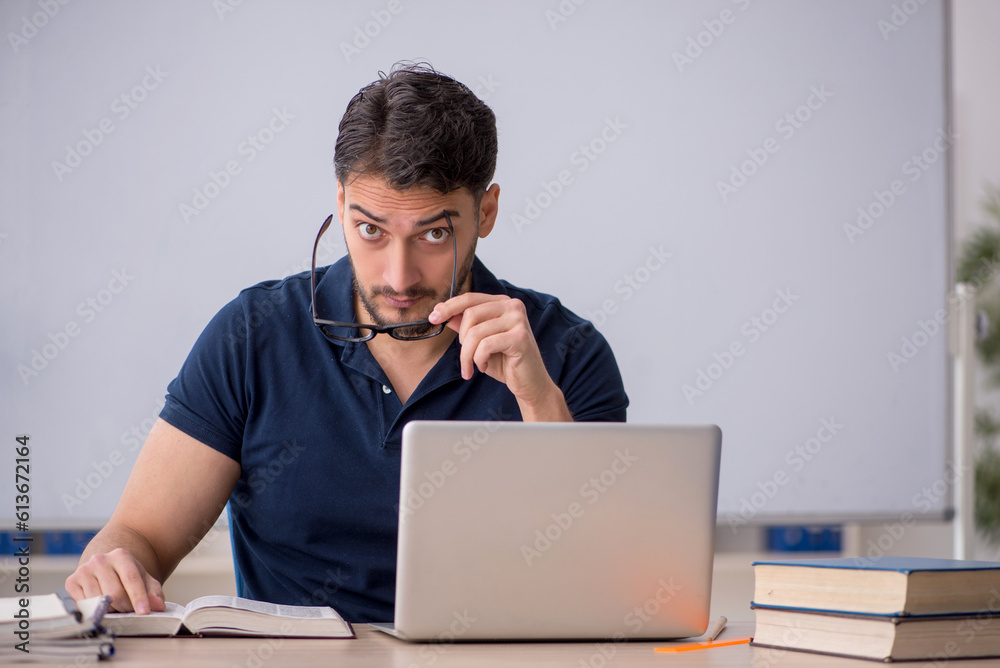 Young male teacher in telestudying concept