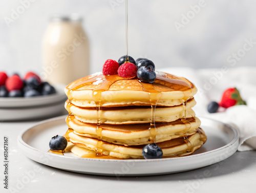 A stack of fluffy pancakes drizzled with maple syrup and topped with fresh berries.