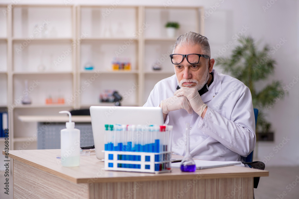 Old male chemist working at the lab Old male chemist working at the lab