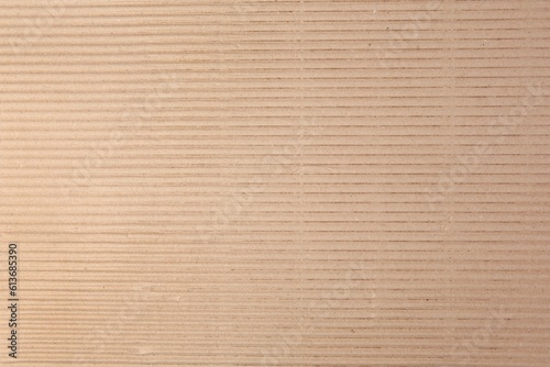 Texture of beige corrugated paper sheet as background, closeup