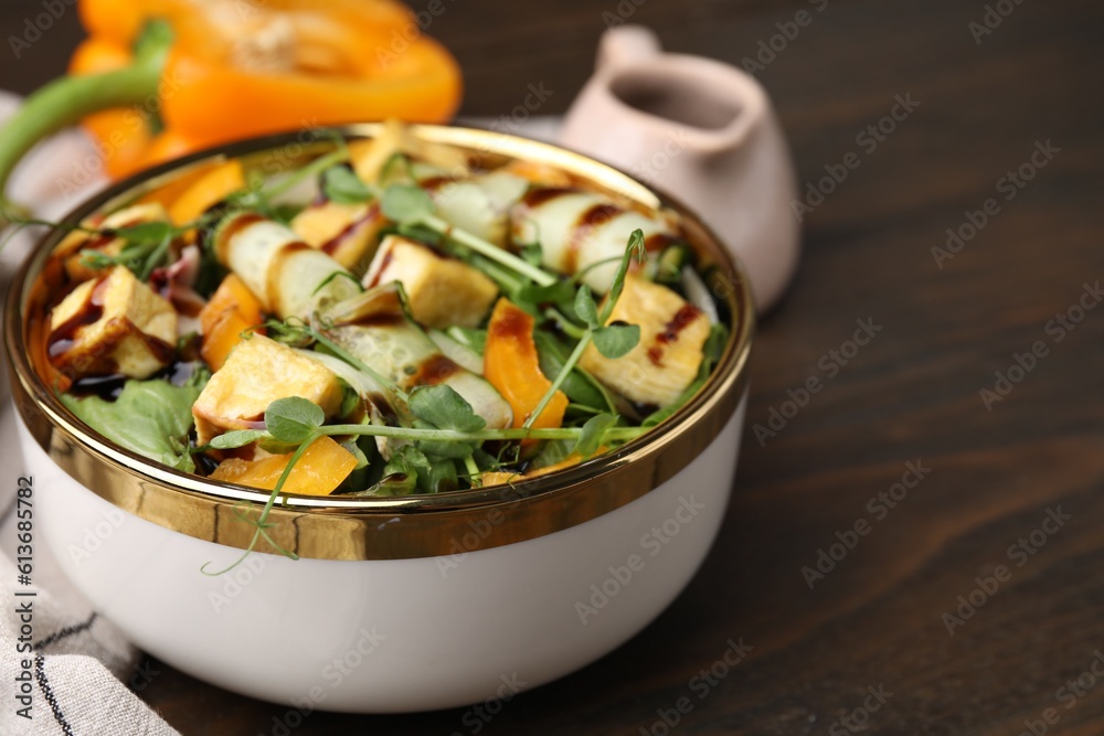 Delicious salad with tofu, vegetables and balsamic vinegar on wooden table, closeup. Space for text Delicious salad with tofu, vegetables and balsamic vinegar on wooden table, closeup. Space for text