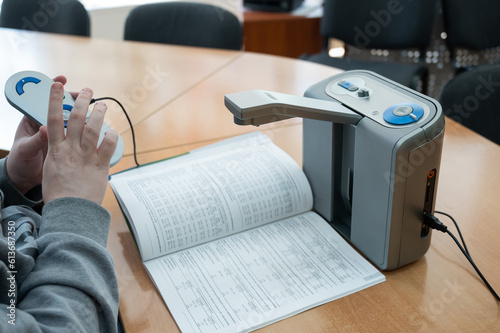 A visually impaired man uses a scanning and reading machine.