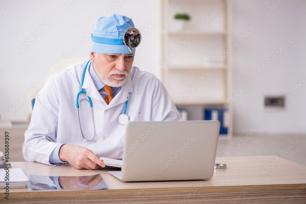 Old male doctor otologist working in the clinic Old male doctor otologist working in the clinic