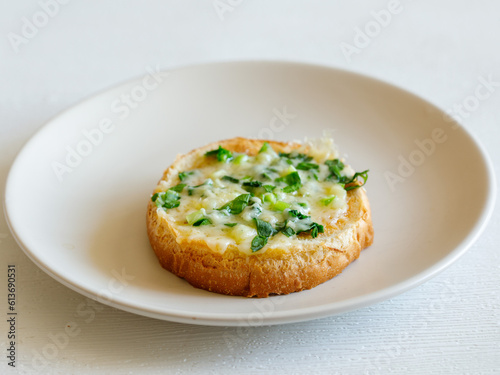 Delicious toasted bread with chopped green wild leek and cheese on plate, close up