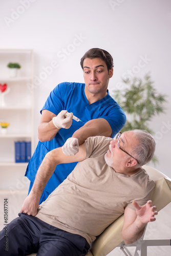 Old male patient visiting young male doctor in vaccination conce