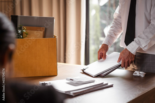 Desperate office manager gathering personal stuff into the box. Fired from job concept.