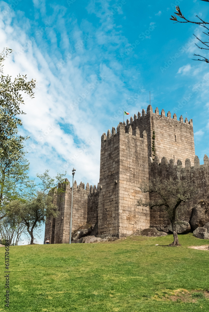 Guimaraes, Portugal. April 14, 2022: Walls and structures of Guimarães castle with blue sky. Guimaraes, Portugal. April 14, 2022: Walls and structures of Guimarães castle with blue sky.