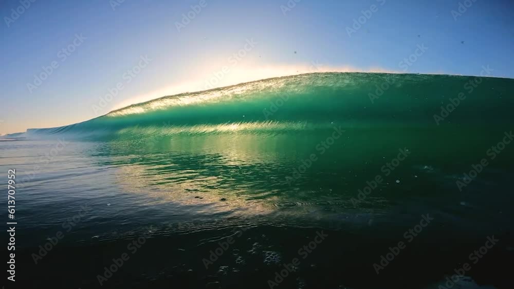 Underwater Slow Motion GoPro shot of wave crashing on sandbar beautiful crystal clear with surfboard and sunrise coastline Central Coast NSW Australia