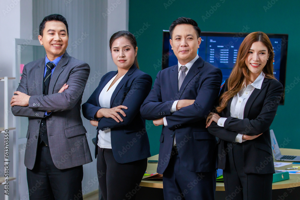 Millennial Asian professional successful group team male female businessmen businesswomen teamwork in formal business suit standing smiling crossed arms side by side in office meeting room together Millennial Asian professional successful group team male female businessmen businesswomen teamwork in formal business suit standing smiling crossed arms side by side in office meeting room together