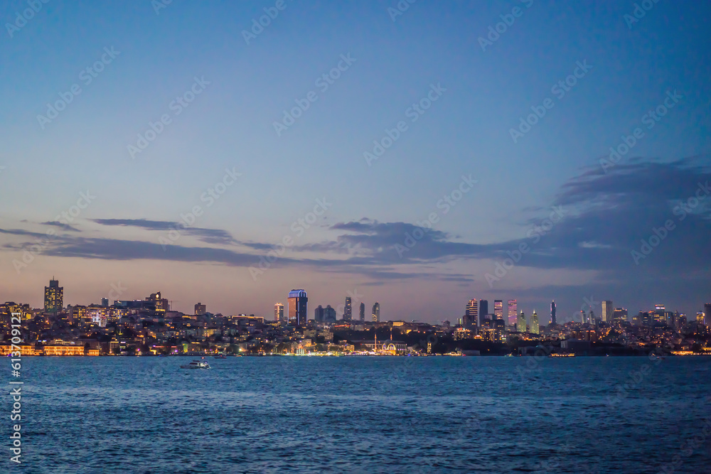 Istanbul at sunset, Turkey. Tourist boat sails on Golden Horn in summer. Beautiful sunny view of Istanbul waterfront with old mosque. Concept of travel, tourism and vacation in Istanbul and Turkey