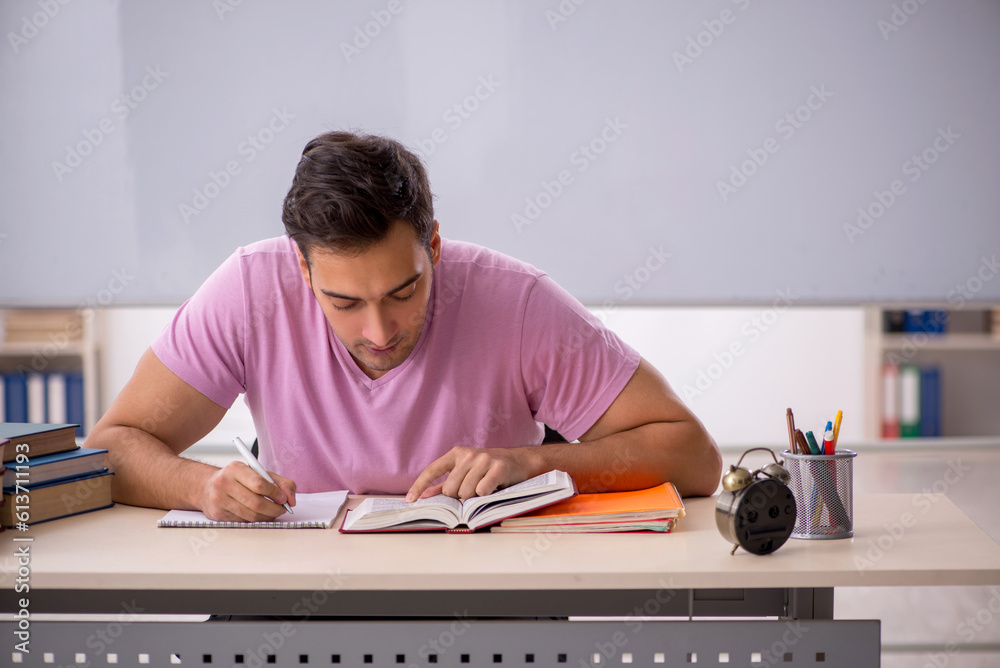 Young male student preparing for exams in the classroom Young male student preparing for exams in the classroom