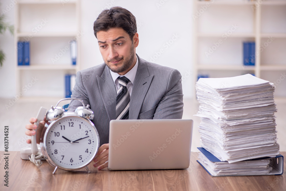 Young male employee in time management concept