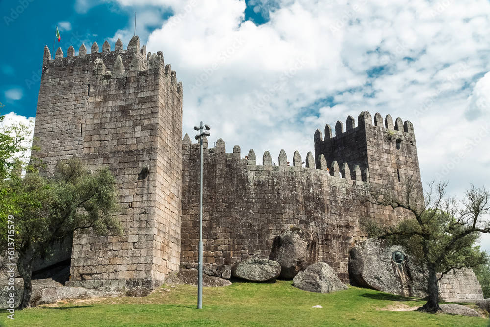 Guimaraes, Portugal. April 14, 2022: Walls and structures of Guimarães castle with blue sky. Guimaraes, Portugal. April 14, 2022: Walls and structures of Guimarães castle with blue sky.