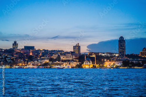 Istanbul at sunset, Turkey. Tourist boat sails on Golden Horn in summer. Beautiful sunny view of Istanbul waterfront with old mosque. Concept of travel, tourism and vacation in Istanbul and Turkey photo