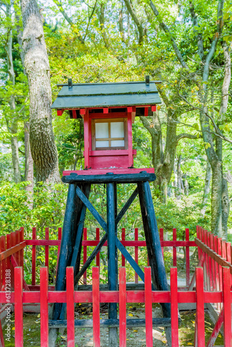Small wooden replica of shinto shrine in Japanese garden park.