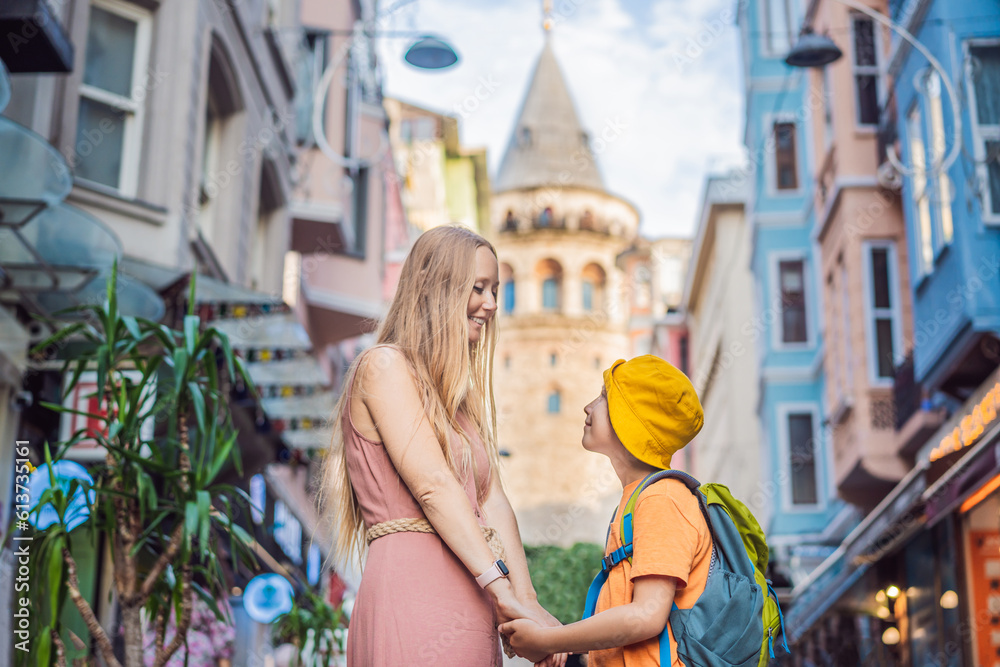 Portrait of beautiful mother and son tourists with view of Galata tower in Beyoglu, Istanbul, Turkey. Turkiye. Traveling with kids concept