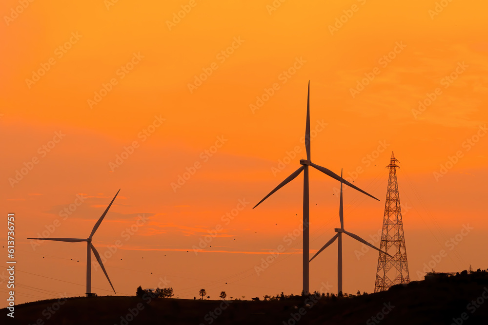 Wind turbines on beautiful summer mountain landscapes in the sunset. Green ecological power energy generation. Wind farm eco field,  renewable energy, clean energy concept, photovoltaic panels