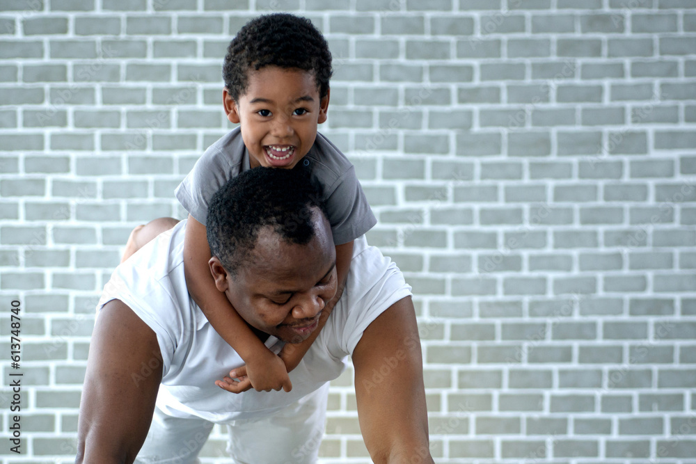 African dad and son exercise on floor at home, man push up from the floor with the boy on his back, father's day African dad and son exercise on floor at home, man push up from the floor with the boy on his back, father's day