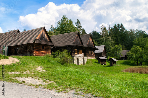 Old wooden houses on a meadow in a small mountain village. Roznov, Czech Republic.