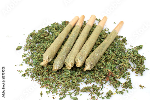 Pre rolled marijuana together with chopped cannabis buds on white background