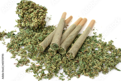 Pre rolled marijuana together with chopped cannabis buds on white background