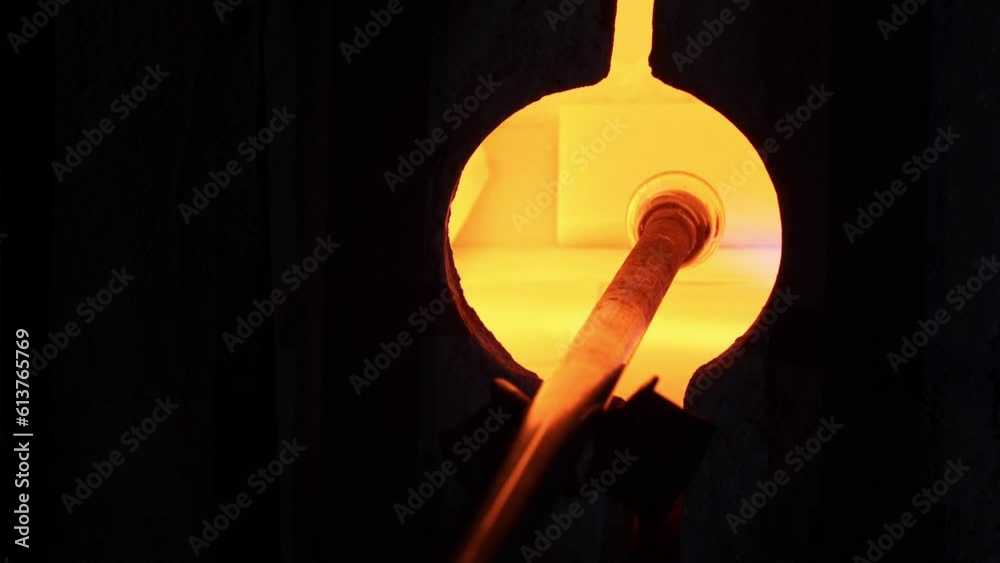 artesano hace botella de vidrio en horno