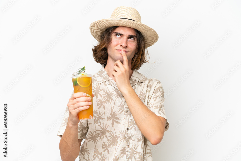 Young handsome man holding a cocktail isolated on white background having doubts while looking up