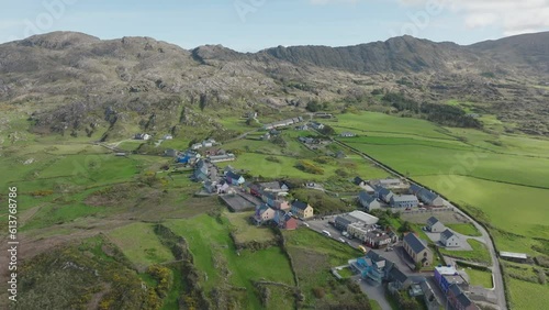 Drone establishing shot flying over colourful Allihies village to the remains of an old Coppermine workings in the mountains of West Cork Ireland on a sunny spring day photo