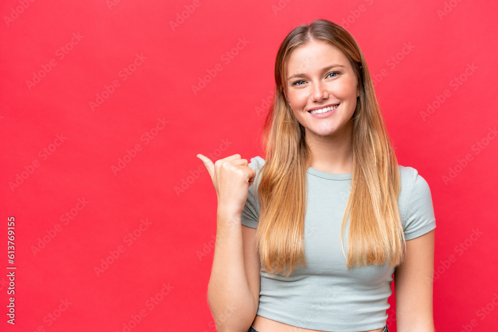 Young beautiful woman isolated on red background pointing to the side to present a product Young beautiful woman isolated on red background pointing to the side to present a product