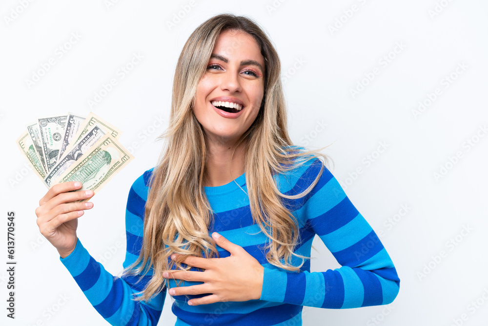 Young Uruguayan woman taking a lot of money isolated on white background smiling a lot Young Uruguayan woman taking a lot of money isolated on white background smiling a lot