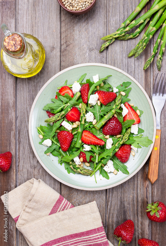 Salad with strawberries, asparagus, arugula, white cheese and nuts. Healthy eating. Vegetarian food.