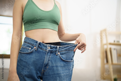 Asian woman dieting Weight loss. Slim woman in oversize jeans 
