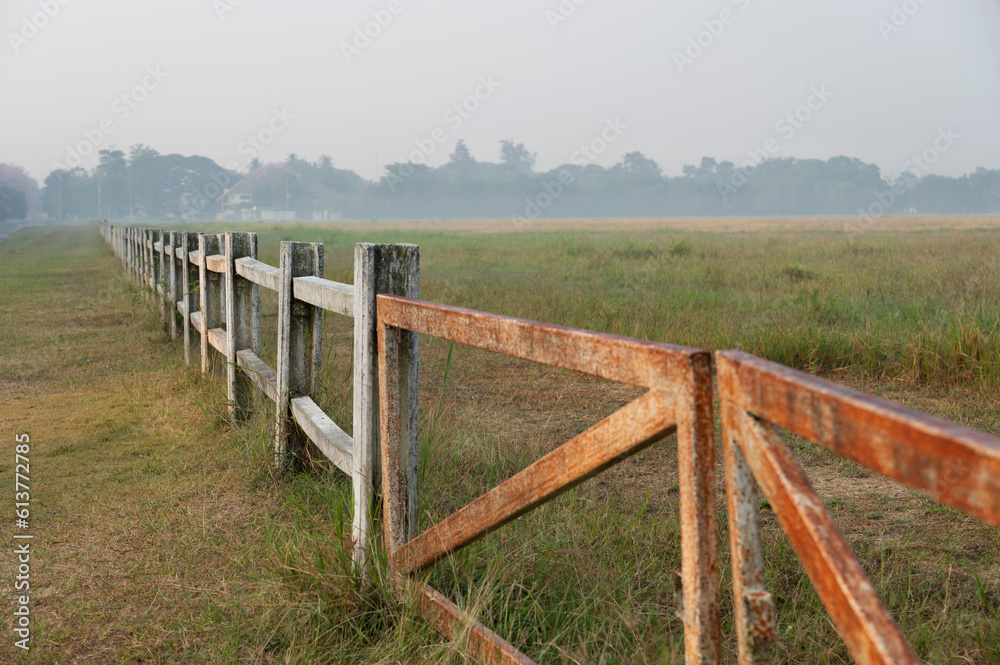 Horse farm with old wooden fence on dry pasture of natural landscape